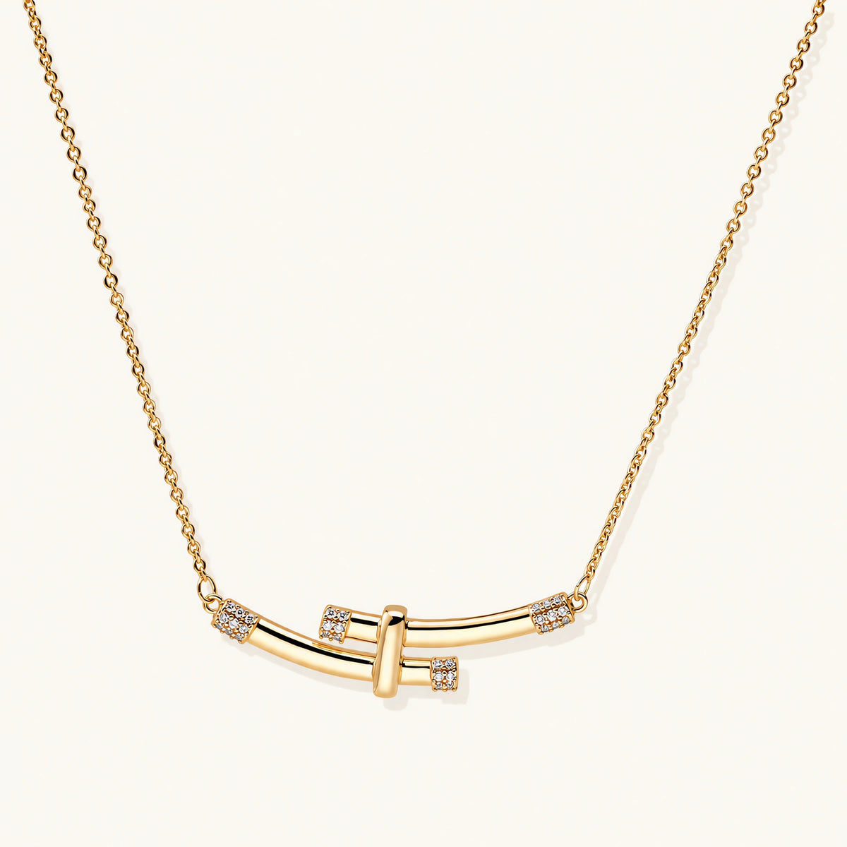 Gold-plated curved bar necklace with diamond accents on delicate chain against cream background