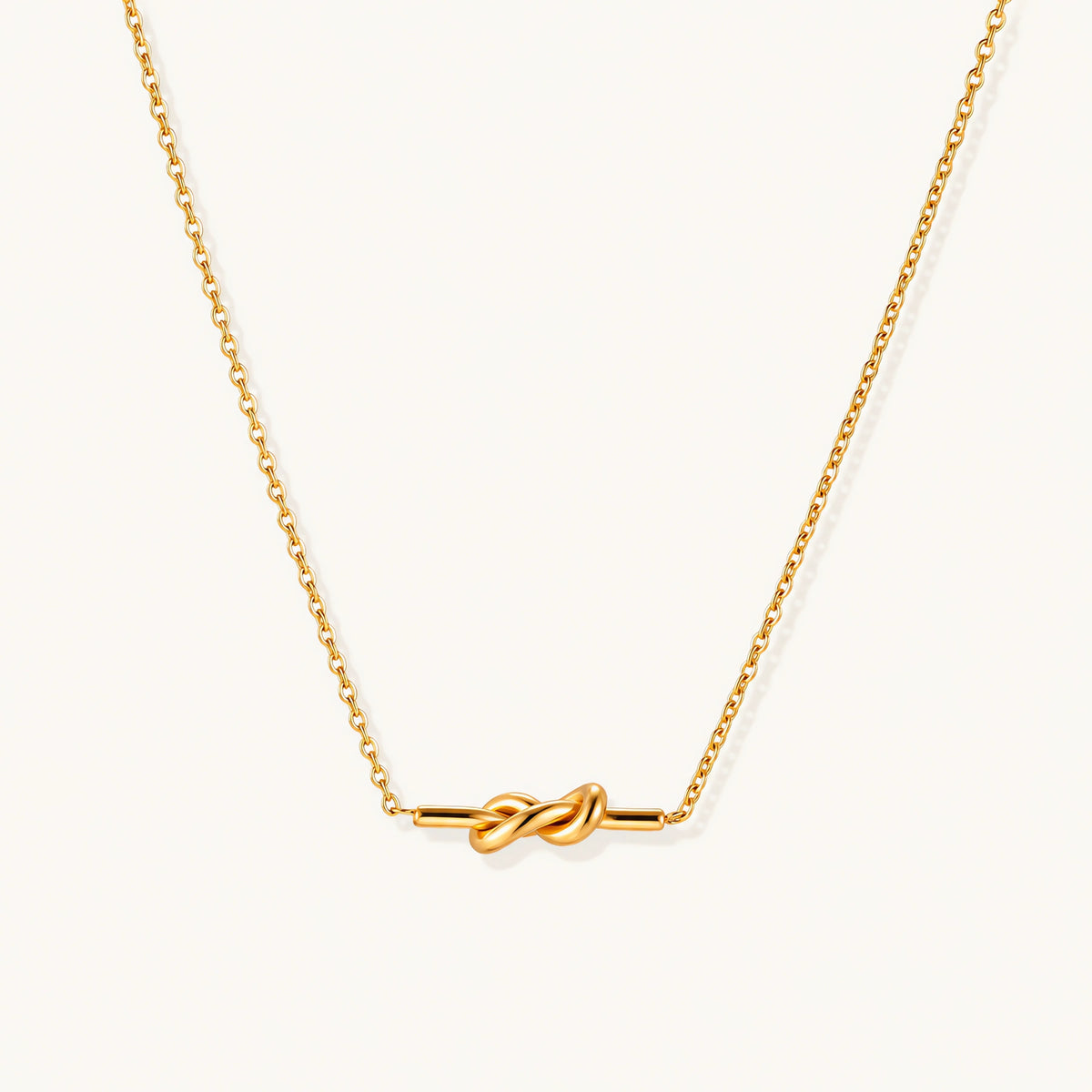 Dainty 18K gold plated necklace with infinity knot pendant on delicate chain against white background